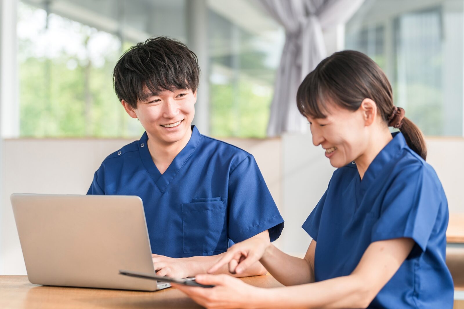 訪問看護スタッフがラップトップを共有している様子